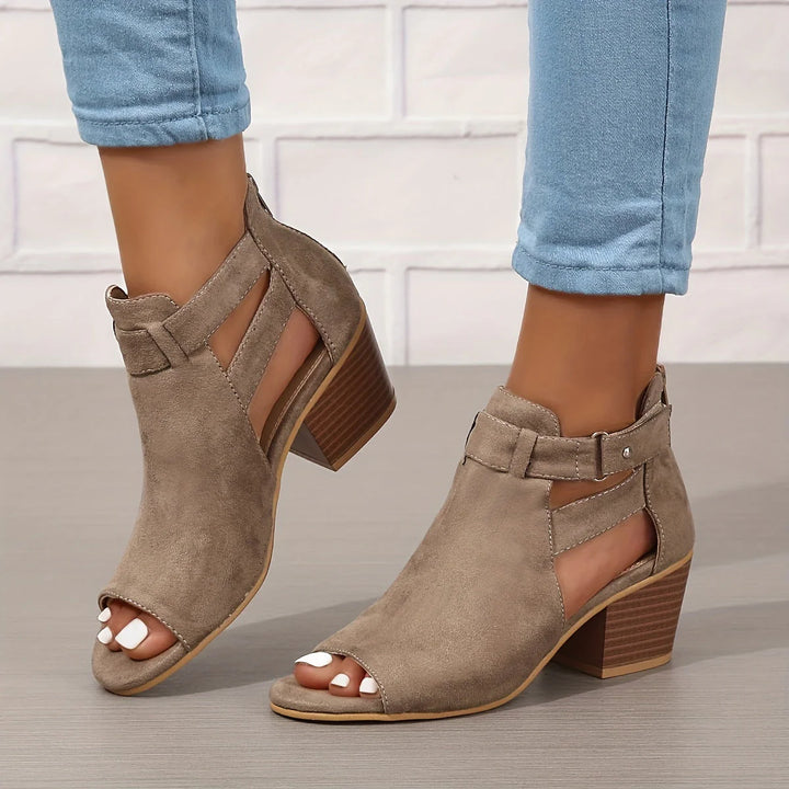 Detailed view of stacked block heel and cut-out upper on women's sandals