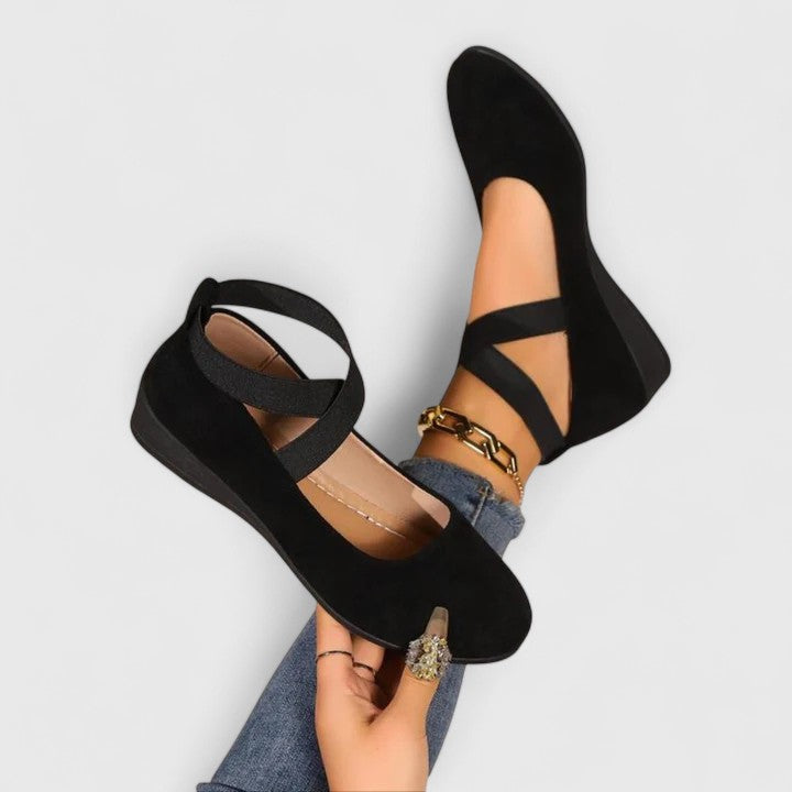 Women's orthopedic cross strap shoes in black with elastic straps and supportive footbed on model