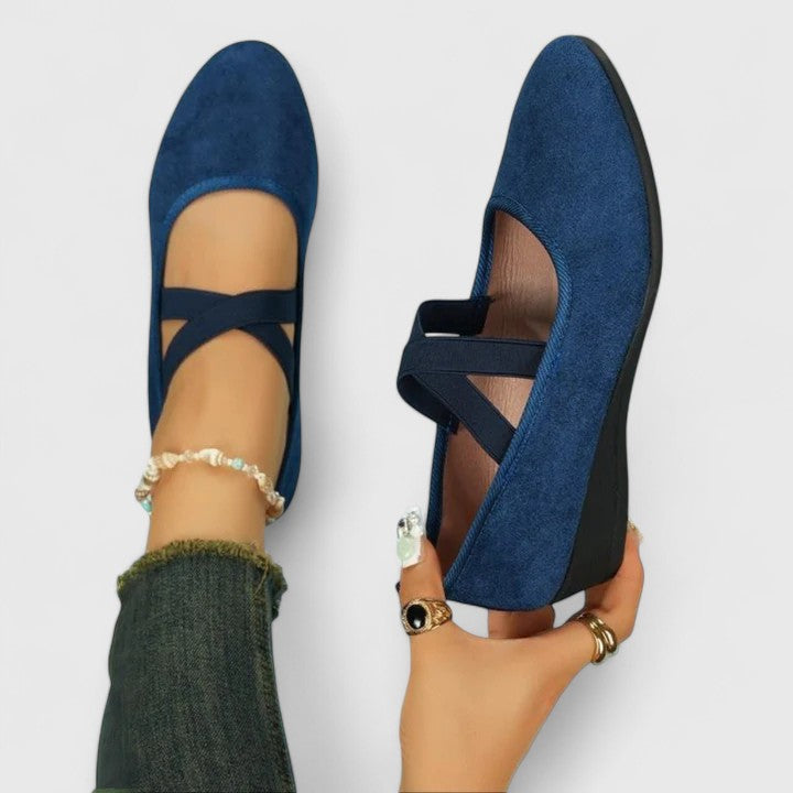 Close-up view of black orthopedic cross strap shoes showing crisscross elastic design and rounded toe