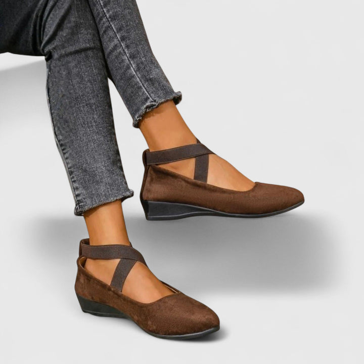 Side angle of women's black orthopedic cross strap shoes displaying slip-on design and supportive sole