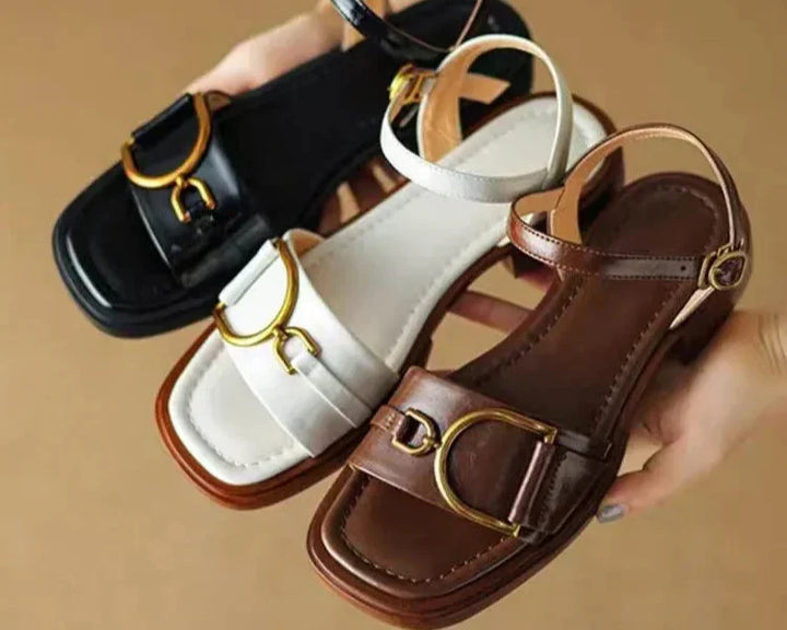 Detail of rubber-edged flat sole and buckle closure on women's ankle strap leather sandals
