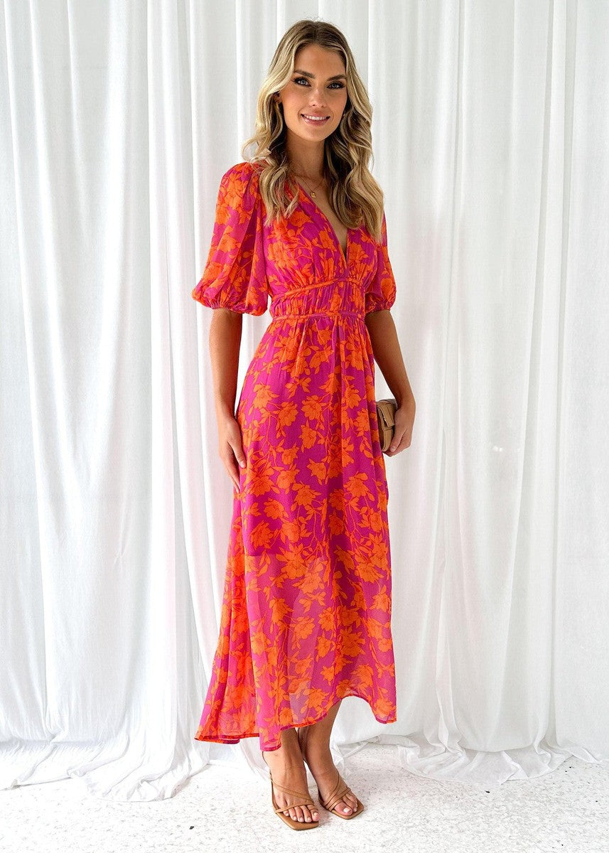 Women's wedding guest dress in bold floral print with flowing ankle-length skirt