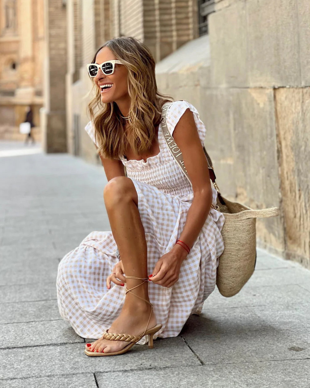 Close-up view of smocked square neckline and ruffled cap sleeves on gingham summer maxi dress