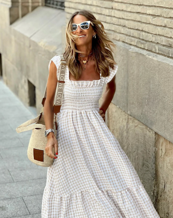 Side angle showing flowing tiered skirt and empire waist detail of smocked summer maxi dress