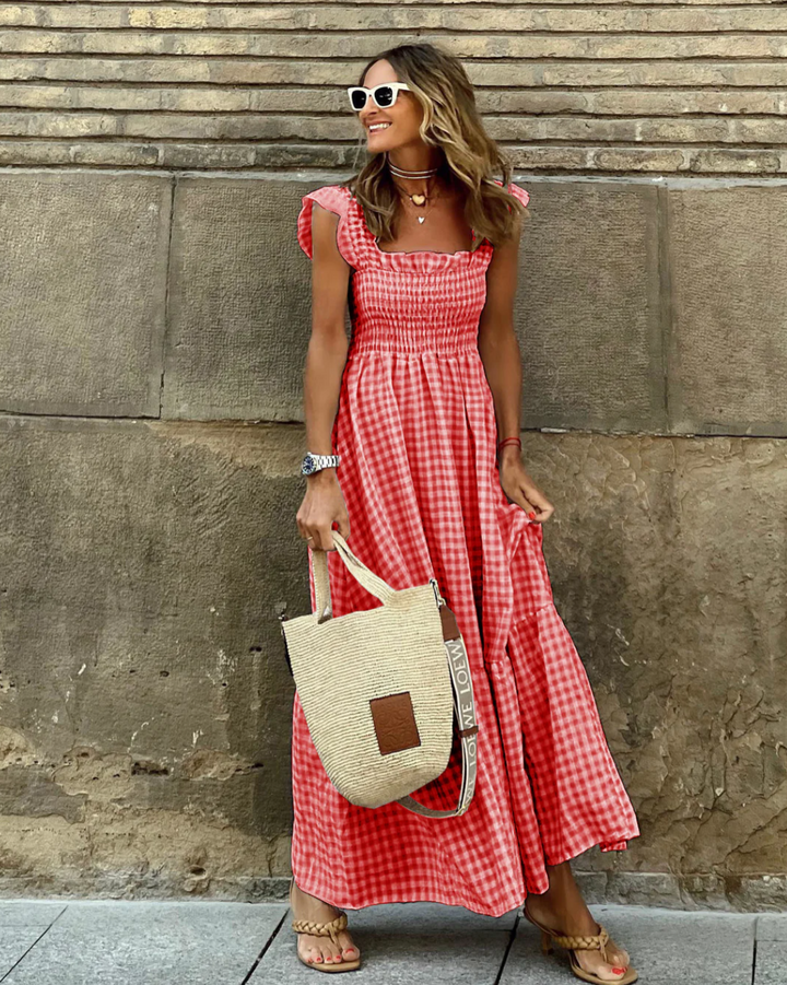 Woman styling smocked summer maxi dress with sandals and straw bag for casual occasion
