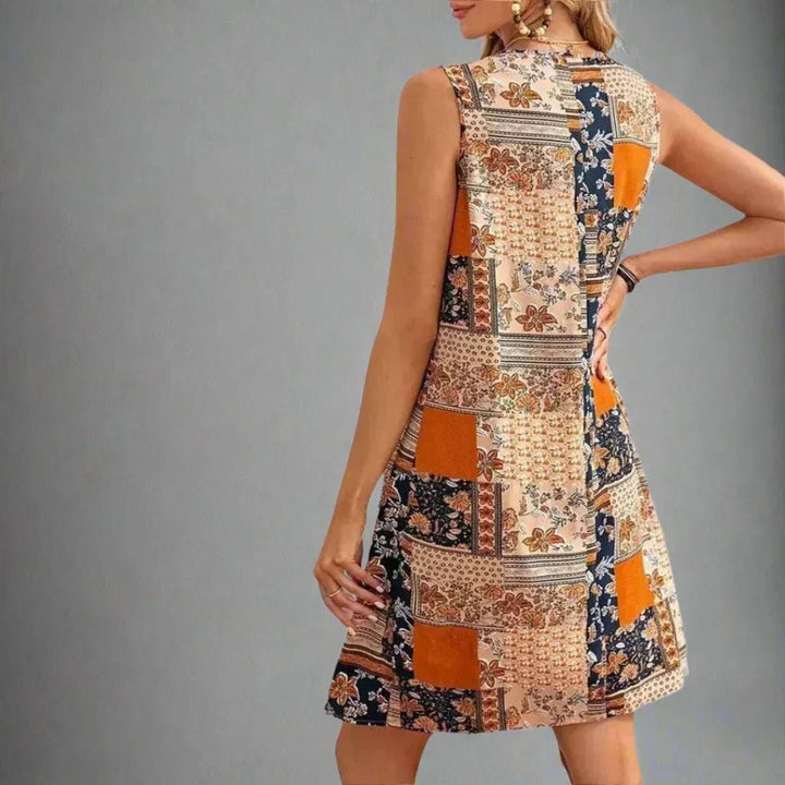 Close-up of patchwork print detail showing ethnic-inspired patterns and warm-toned colour blocking on mini dress