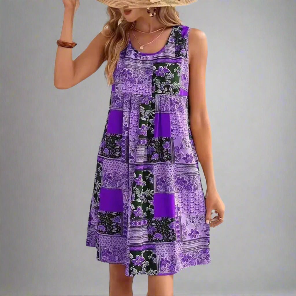 Detail of scoop neckline and sleeveless cut on mini dress with multi-pattern patchwork design in summer colours