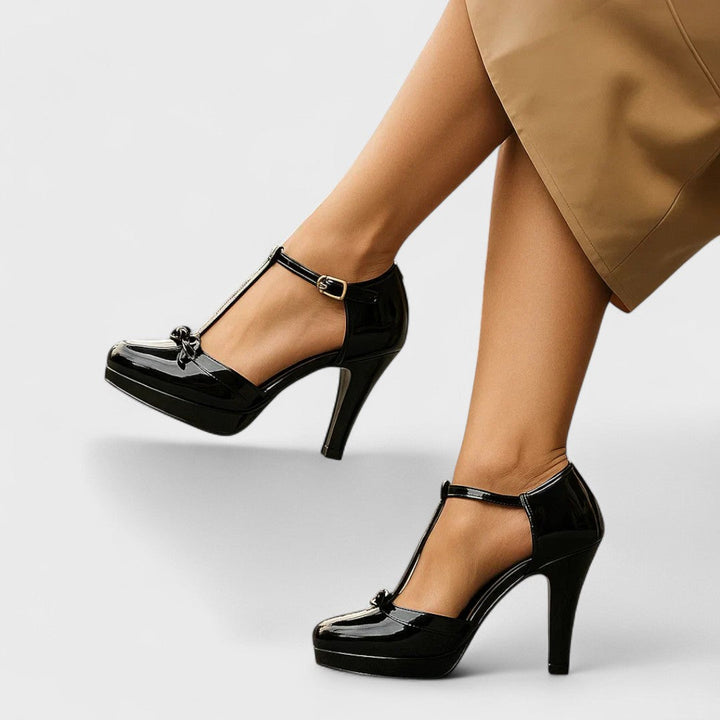 Orthopedic T-Strap Heels in formal setting, showing bow detail and contrasting black trim on nude upper