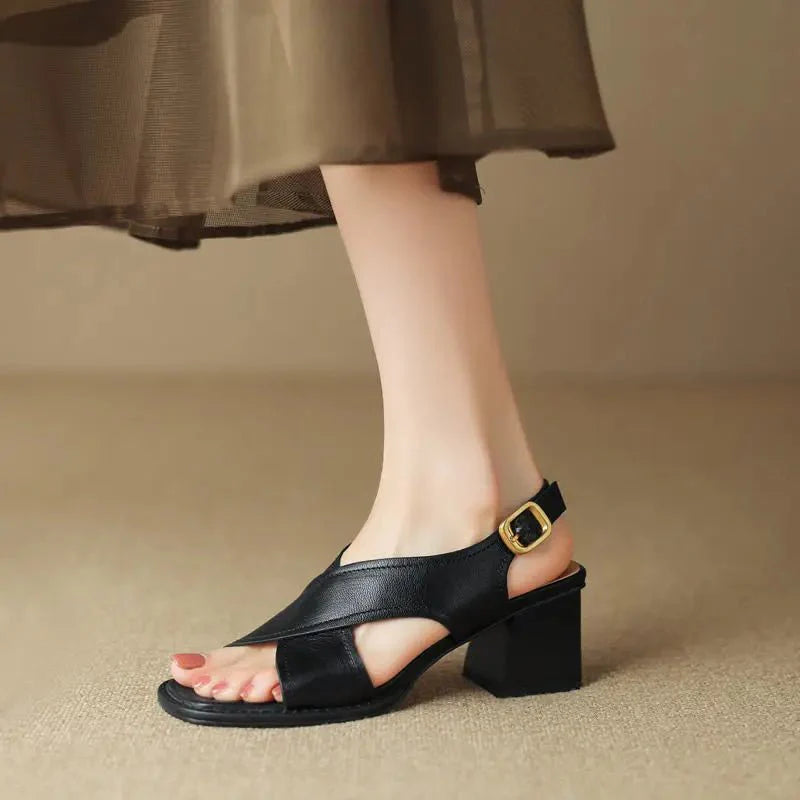 Charlotte wearing Women's Fisherman Sandals Leather Crossover Low Block Heel in black with gold-tone buckle and square open toe