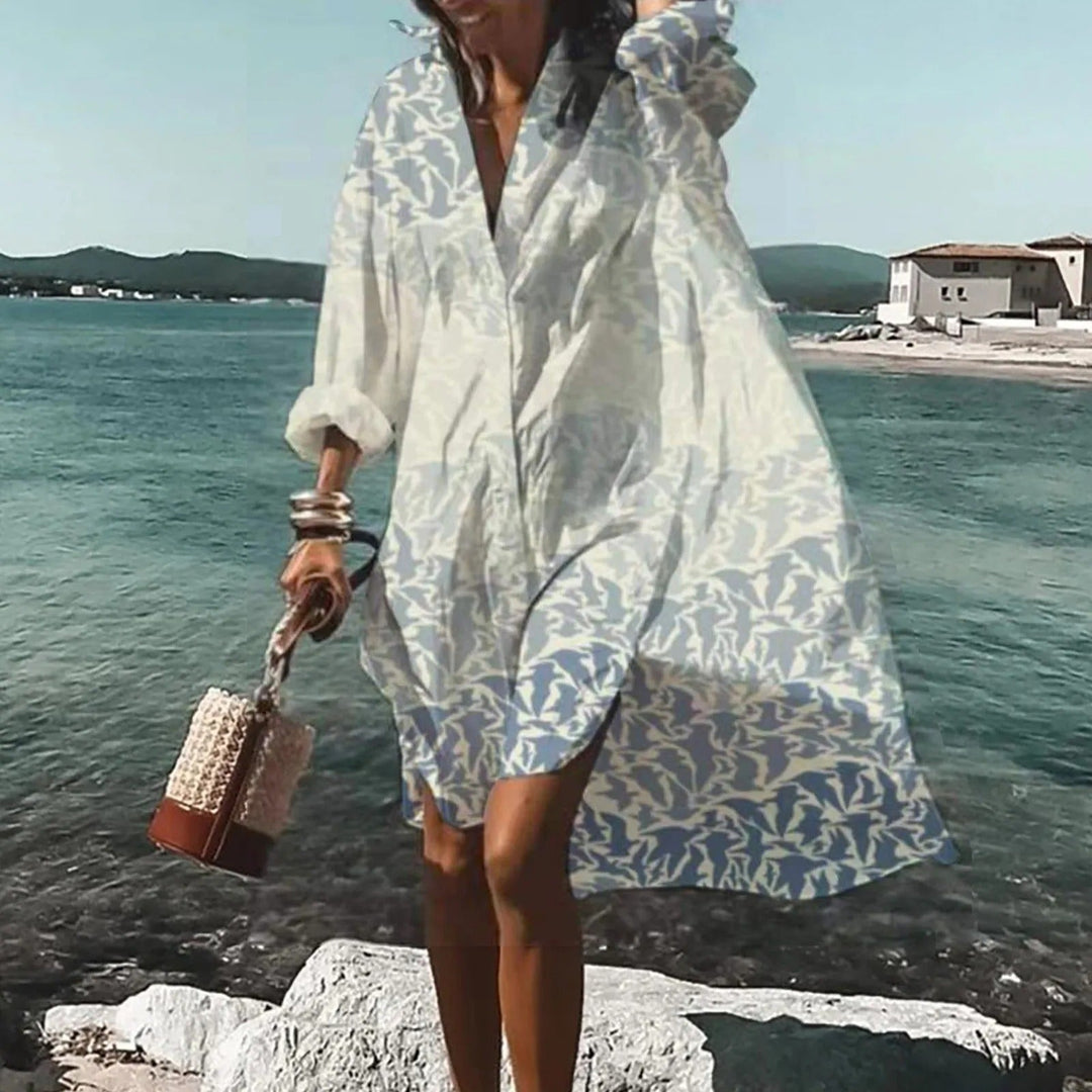 Woman wearing a Women's Summer Casual Shirt Dress in light blue floral print by the seaside
