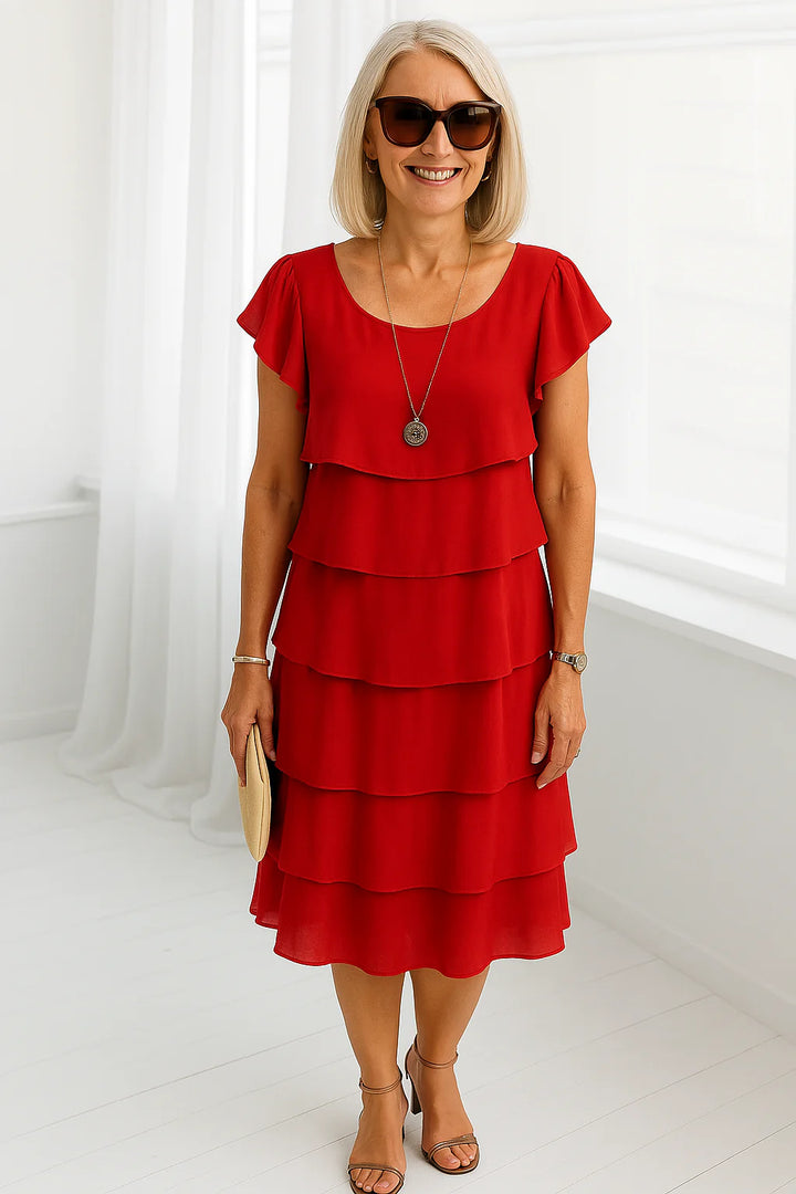 Tiered midi dress in vibrant red with layered skirt and short flutter sleeves styled with sunglasses