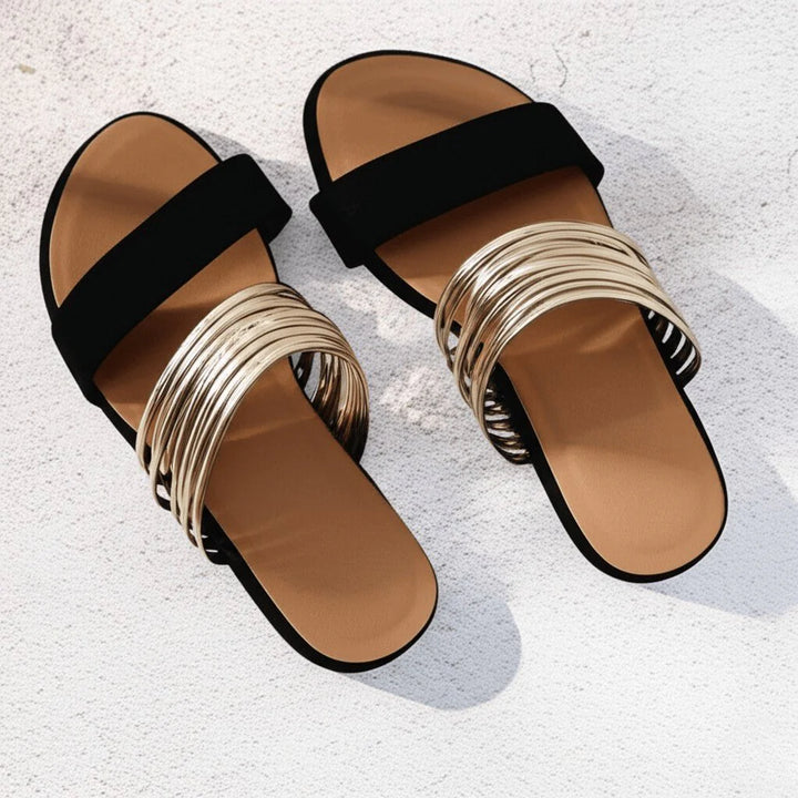 Full view of women's orthopedic sandals featuring black fabric straps, metallic toe detail, and contoured arch support footbed