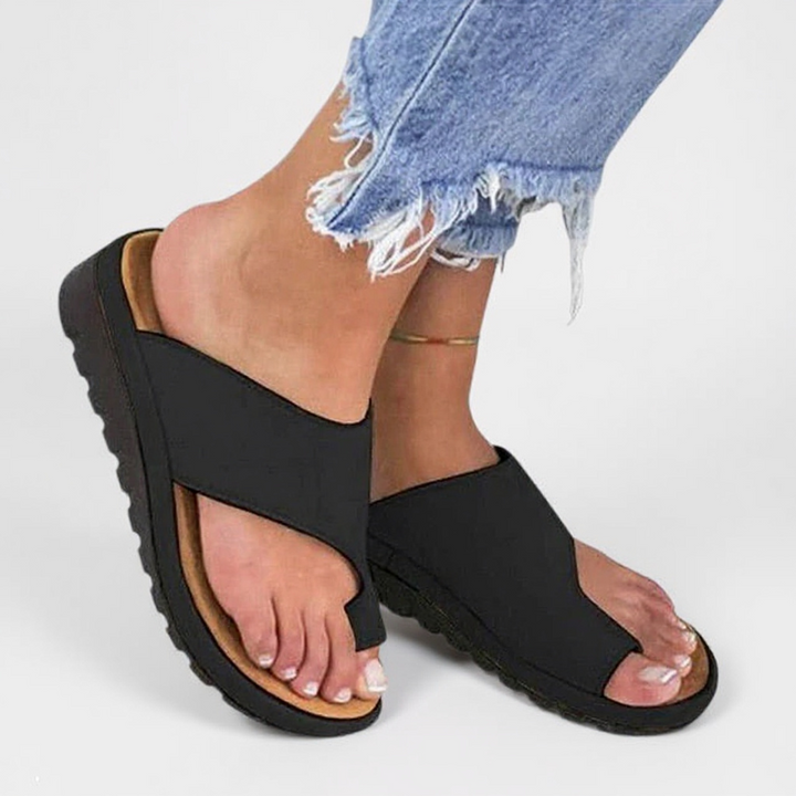 Women's Summer Orthopedic Toe Split Sandals with black crossover straps and textured sole worn with distressed jeans