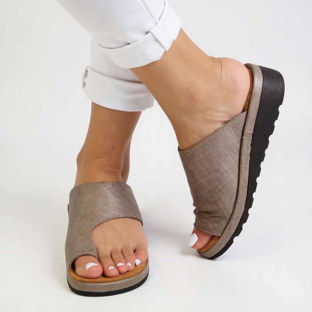 Close-up view of black orthopedic toe split sandals showing wide toe-post design and supportive footbed construction