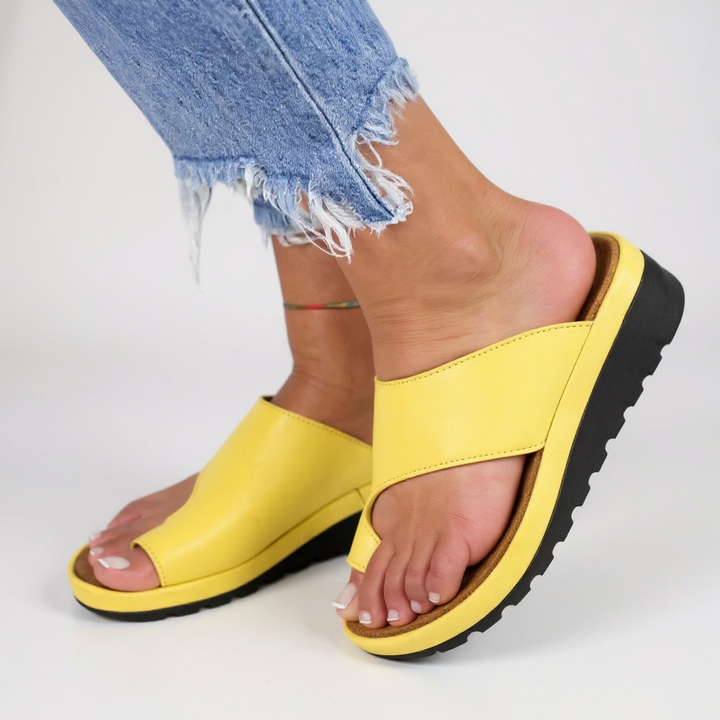 Detail of crossover strap design on orthopedic sandals with cushioned footbed and rubber outsole