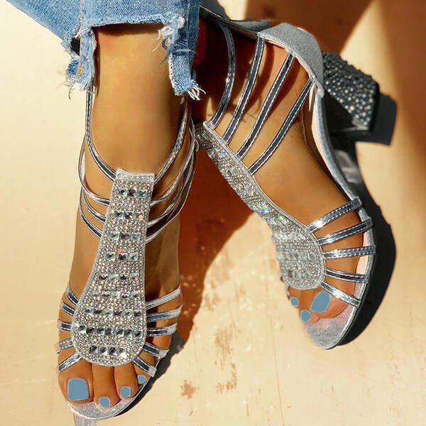 Detail shot of block heel with textured embellishment and metallic strap construction