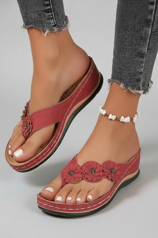 Detail of floral embellished toe-post sandals with visible stitching and cushioned insole for shock absorption