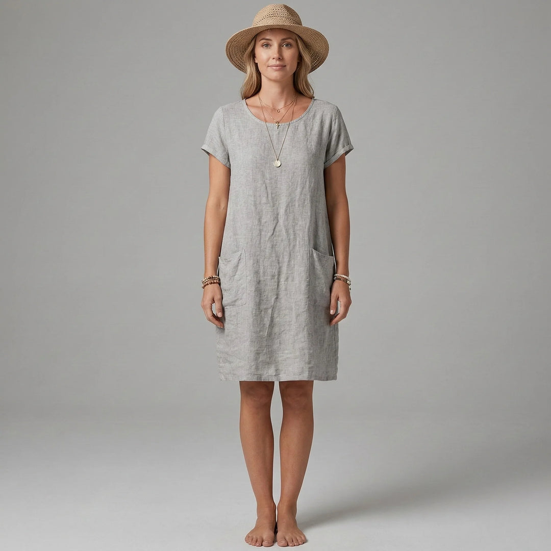 Woman wearing grey short sleeves and pockets dress with relaxed shift silhouette and knee-length hem