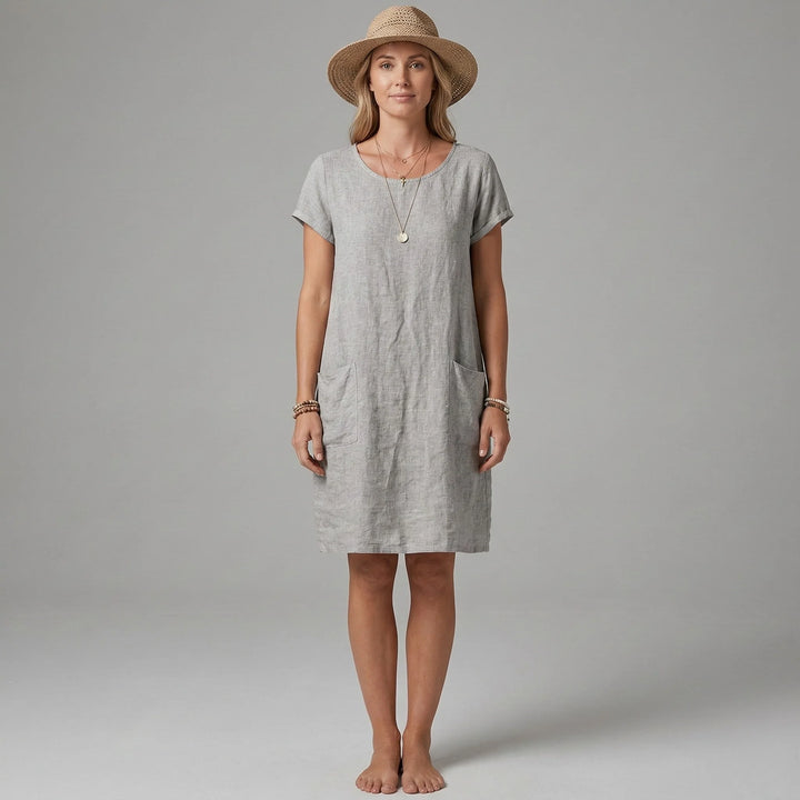 Woman wearing grey short sleeves and pockets dress with relaxed shift silhouette and knee-length hem