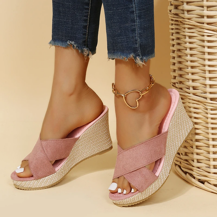 Women's platform wedge sandals worn with cropped denim showing slip-on crossover strap design