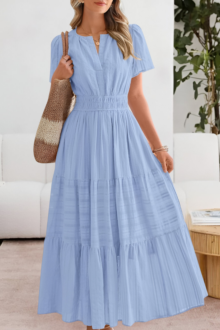 Movement shot capturing the flowing tiered skirt of the relaxed midi dress