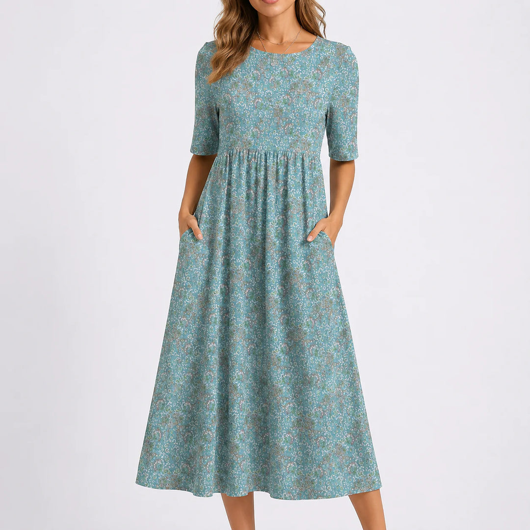 Floral midi dress with round neckline, half sleeves, gathered waist, and all-over floral print in soft tones