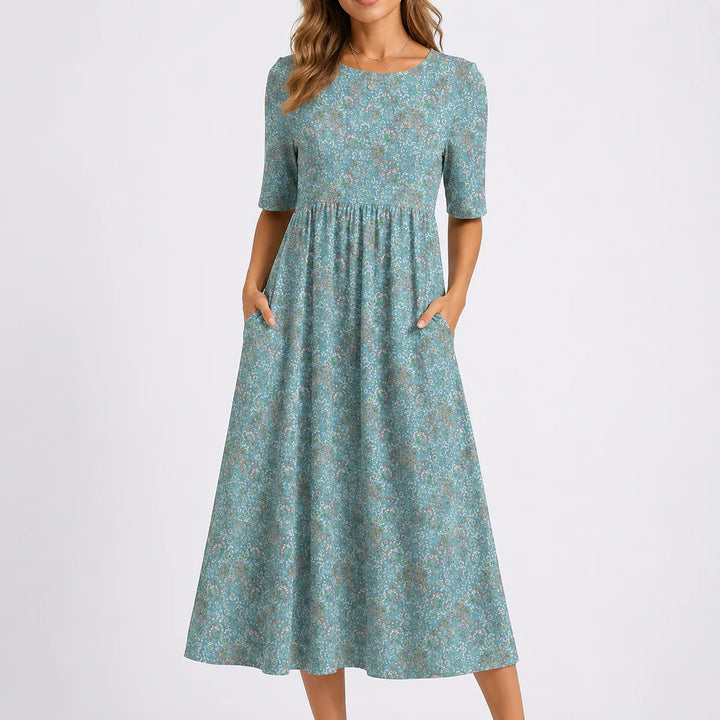 Floral midi dress with round neckline, half sleeves, gathered waist, and all-over floral print in soft tones