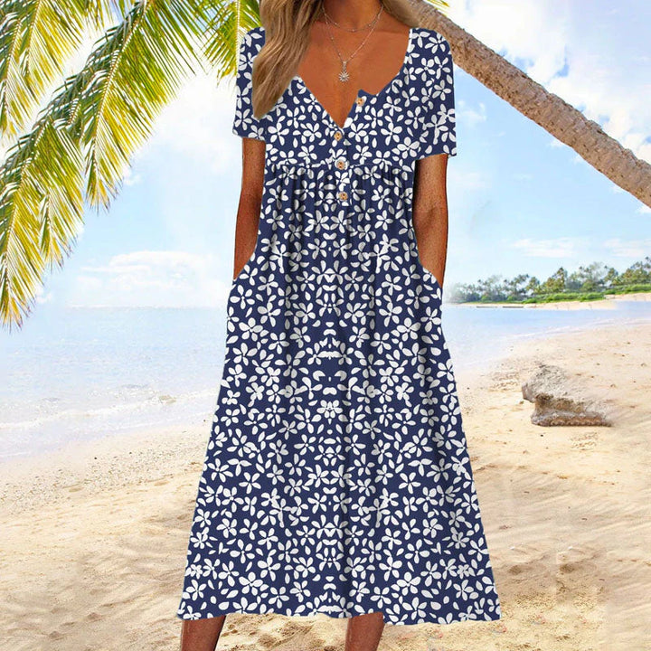 Close-up of floral summer dress showing white floral print on navy fabric with button details