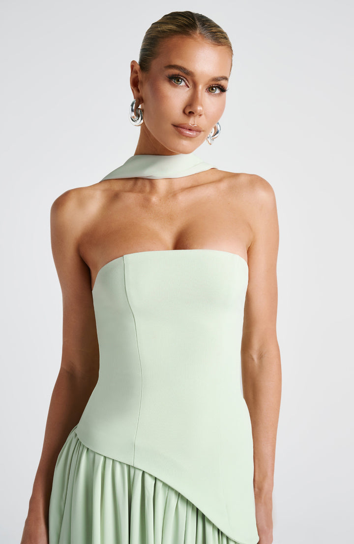 Movement detail of the high front slit and draped maxi-length skirt
