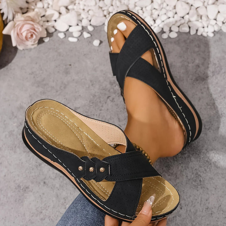 Side angle of orthopaedic wedge sandals highlighting supportive footbed and wedge heel construction