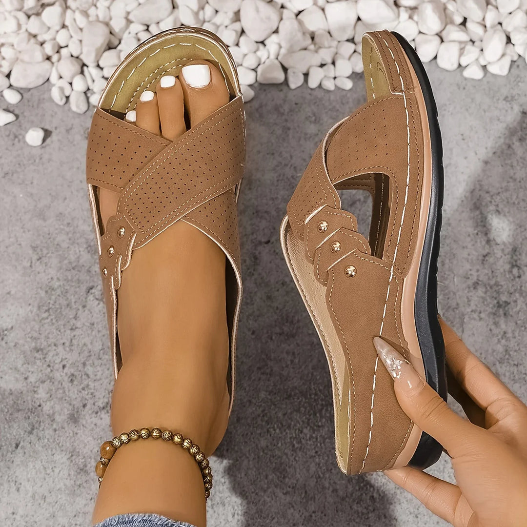 Detail of contrast stitching and metal buckle hardware on women's wedge sandals