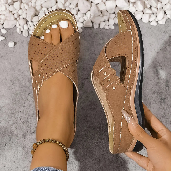 Detail of contrast stitching and metal buckle hardware on women's wedge sandals