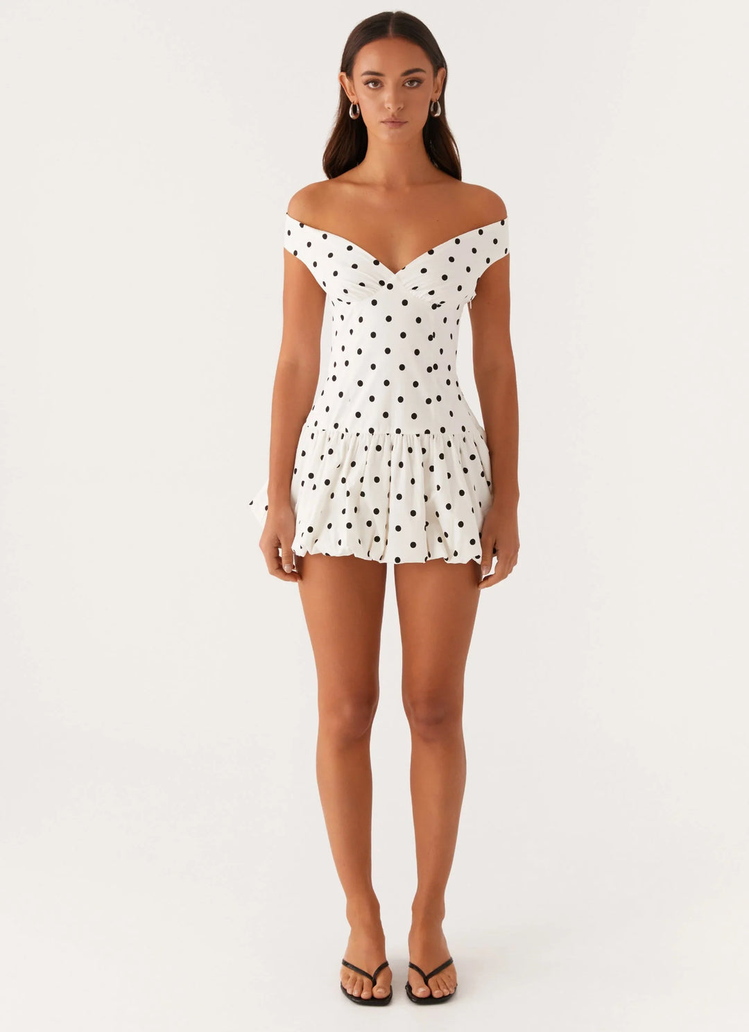 Rear view of the Off-Shoulder Polka Dot Peplum Mini Dress showing the subtle backless detail and polka dot pattern across the structured fabric