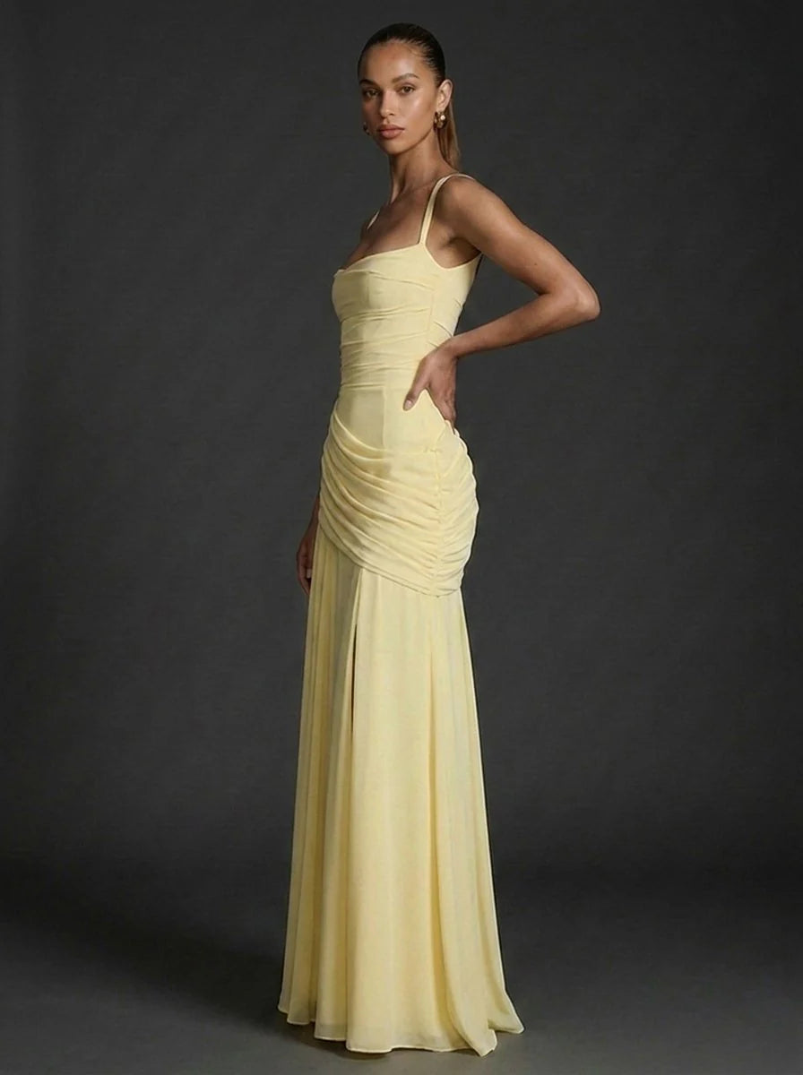 Side angle of sleeveless maxi dress showing ruched bodice and flowing skirt silhouette