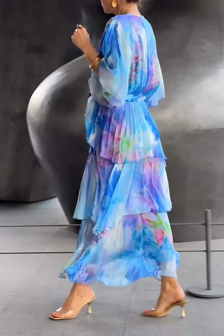 Bohemian maxi dress with flowing tiered silhouette and wrap bodice styled with metallic clutch