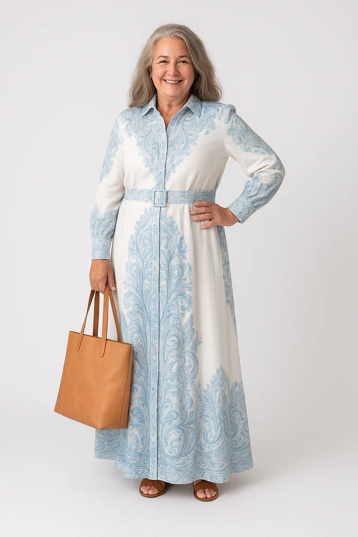 Shirt dress with high neck collar, tie belt at waist, and floor-length hem in paisley print