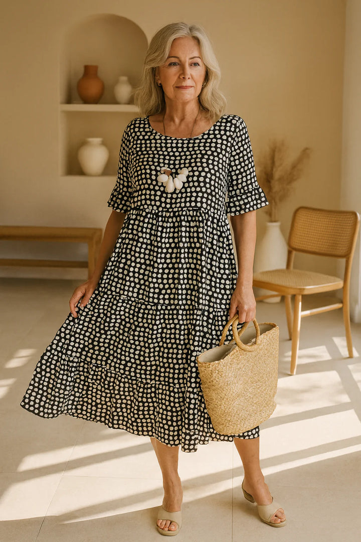 Side angle of tiered midi dress with short sleeves and lightweight woven fabric in neutral tones