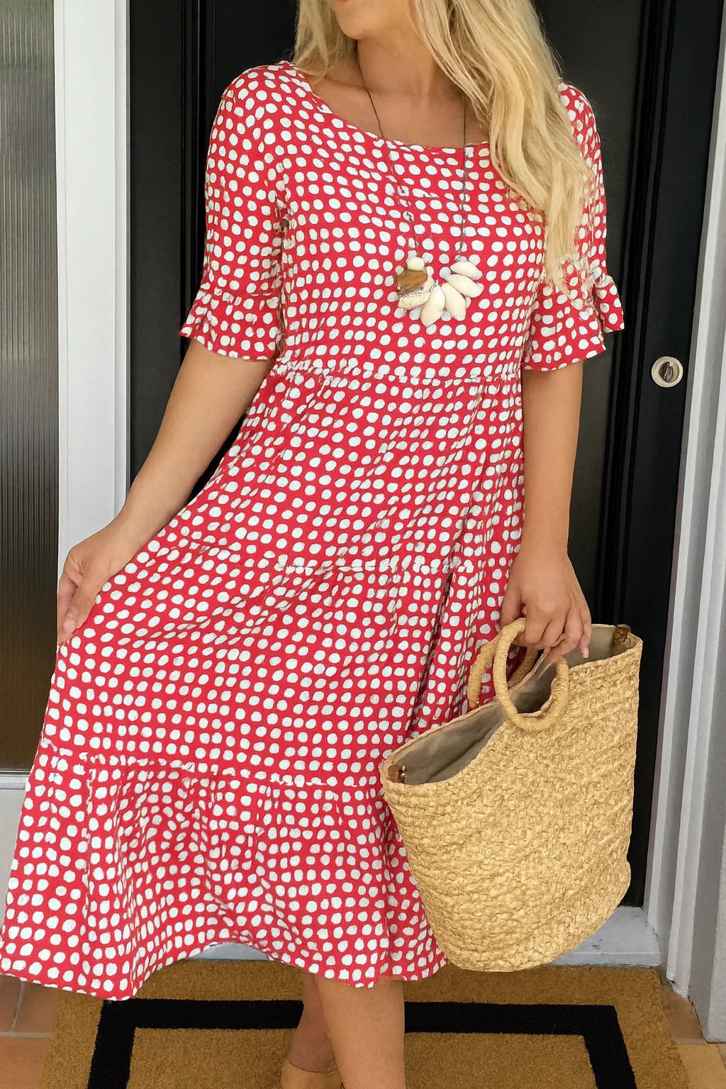 Back view of polka dot midi dress with short sleeves and flowing tiered skirt