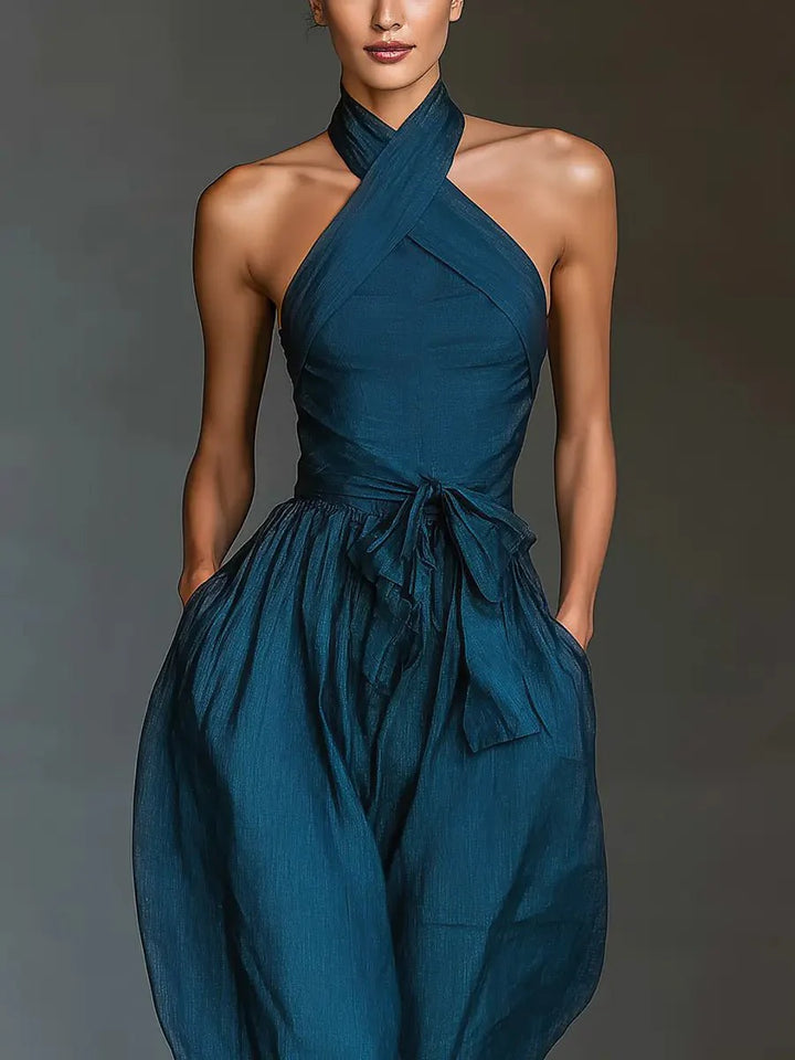 Side angle of Women's Cross Halter Wide-Leg Linen Jumpsuit displaying wide-leg silhouette and natural fabric drape