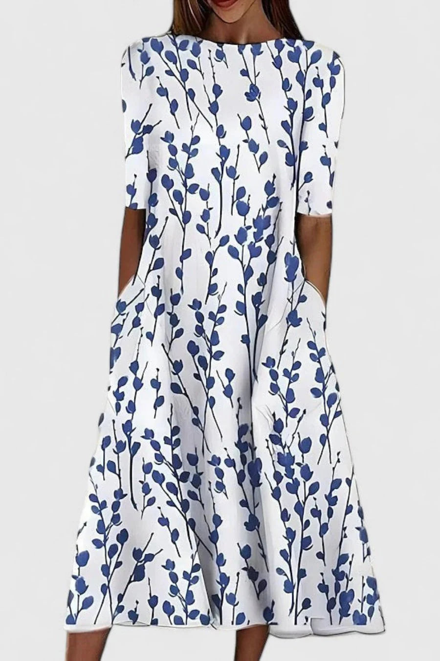 Botanical print midi dress with blue leaf motif on white ground, featuring A-line silhouette and short sleeves