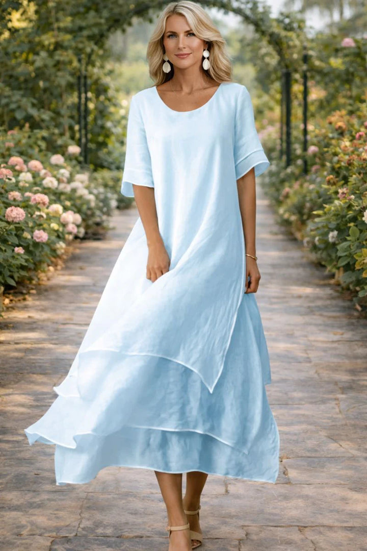 Full-length view of the women's dress with open neckline styled with neutral accessories