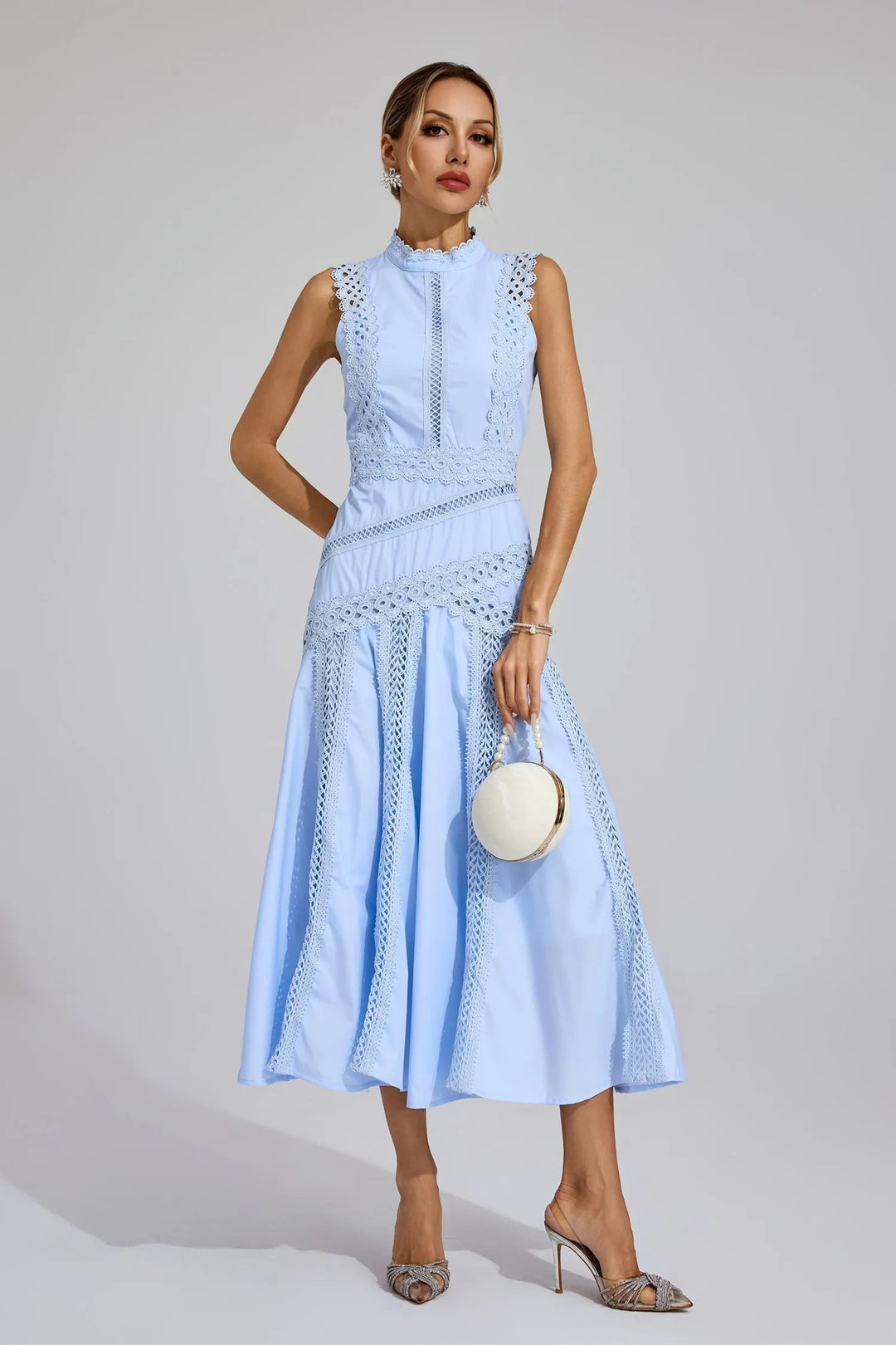 Close-up of lace panelling detail on women's midi wedding guest dress