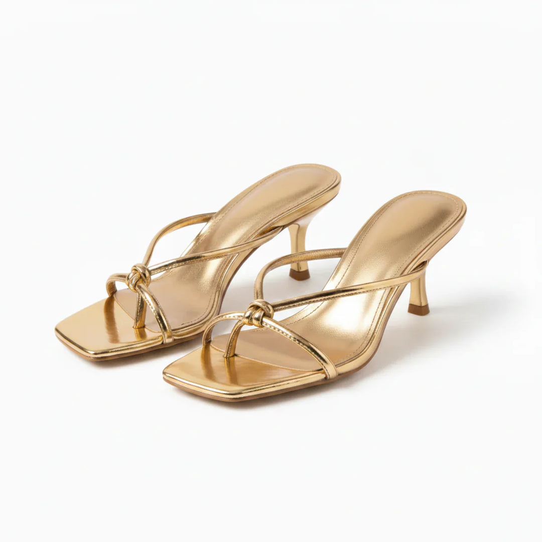 Women's heeled sandals in white worn with bare legs showing slip-on design