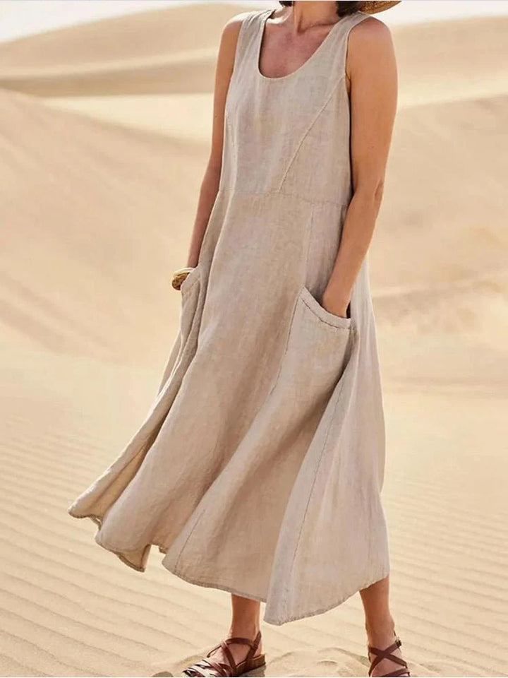 Women's Sleeveless Pocket Maxi Casual Dress in beige with flowing silhouette and side pockets worn outdoors