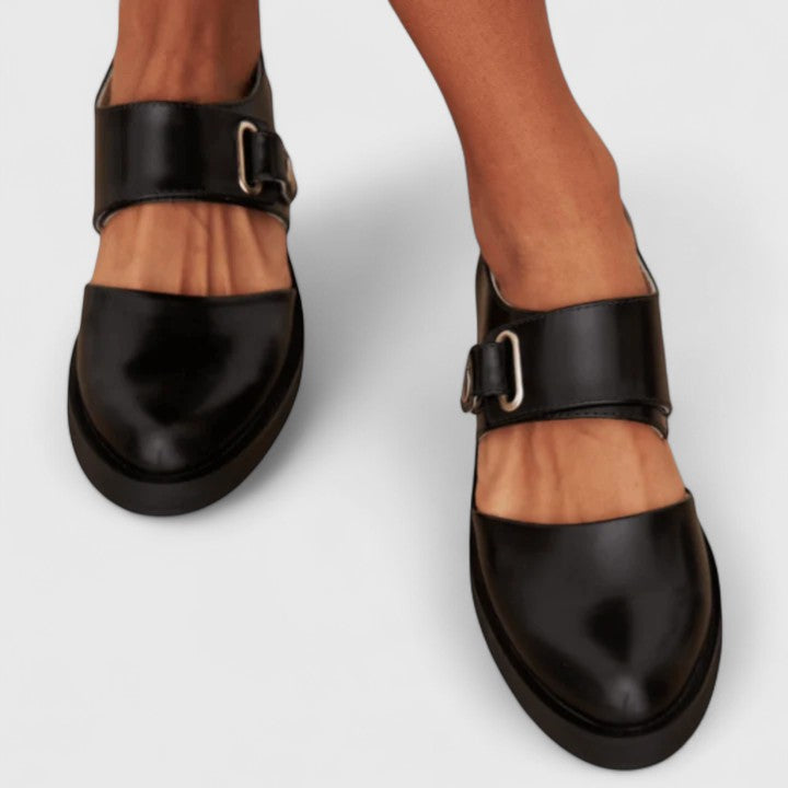 Close-up view of women's black orthopedic buckle shoes featuring refined buckle detailing and smooth finish