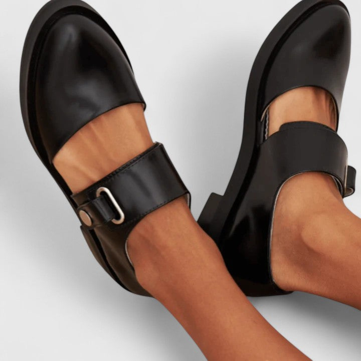 Side angle of women's orthopedic buckle shoes showcasing cushioned sole construction and classic flat design