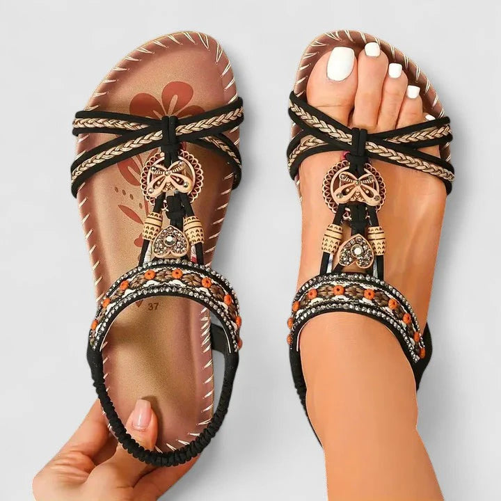 Side angle of women's flat sandals with elastic ankle strap and contoured footbed design