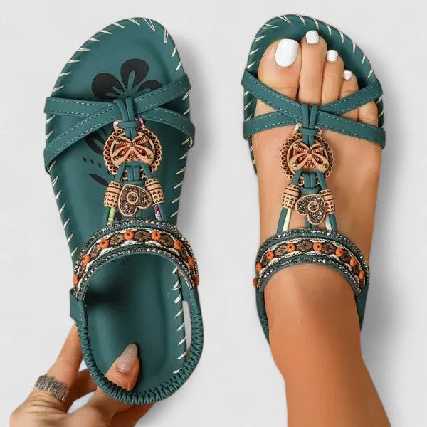 Women's embellished sandals displayed showing secure T-strap design and beaded toe post detailing