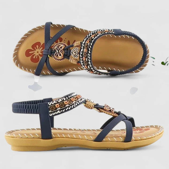 Overhead view of women's flat sandals with beaded embellishments and adjustable elastic ankle strap