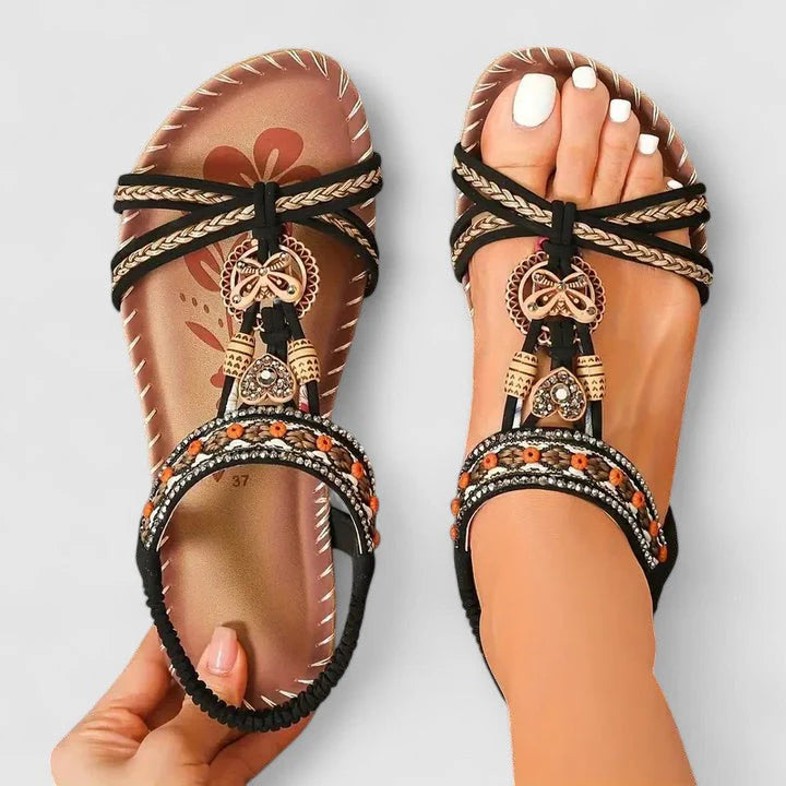 Detail shot of women's T-strap sandals highlighting decorative beadwork and supportive footbed construction